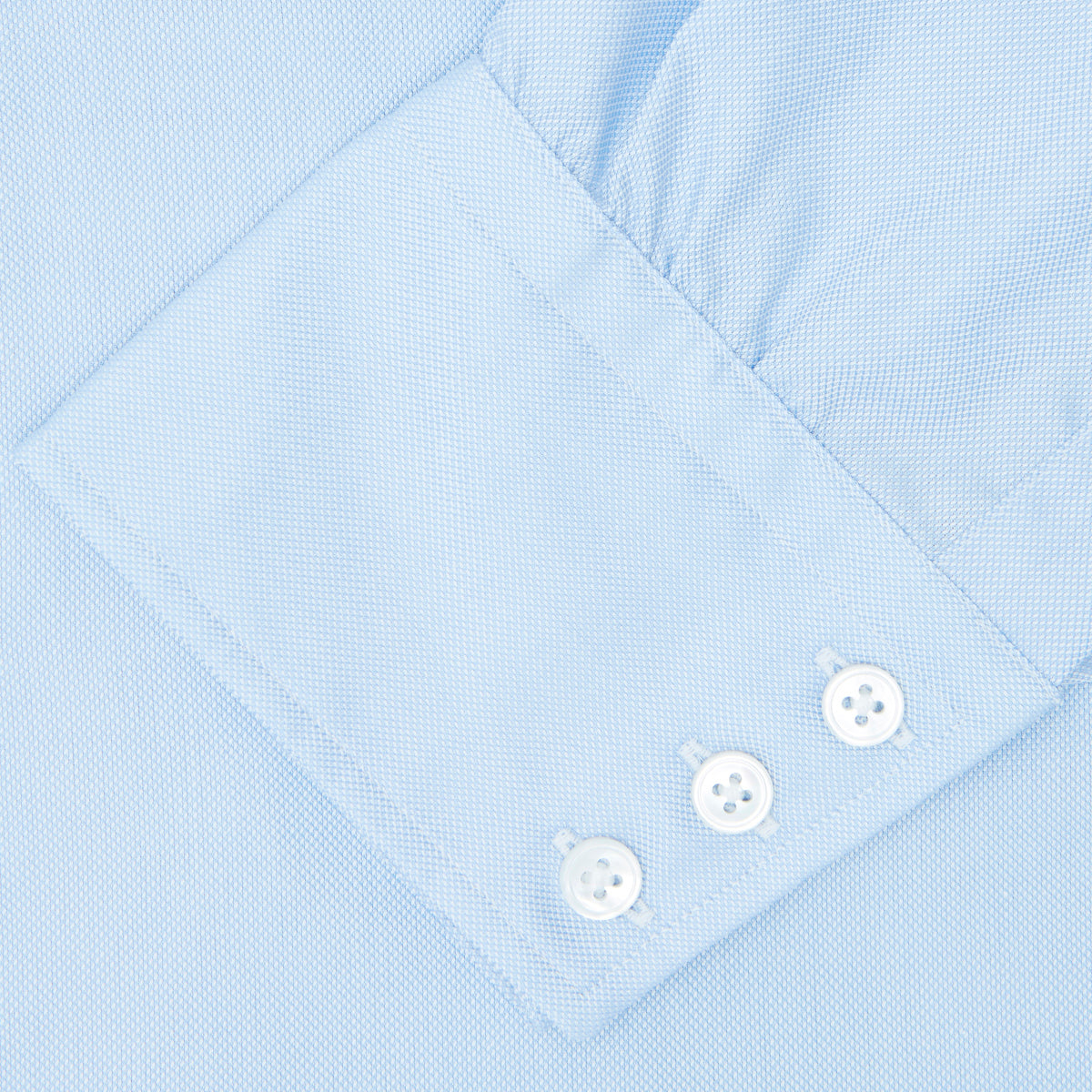 Image 3 of product The Turnbull & Asser Light Blue Royal Oxford Cotton Shirt features a button-down collar, 3-button cuffs, and white buttons. Neatly folded with a visible inner label, it’s ideal to pair with a navy suit and displayed on a plain white background.