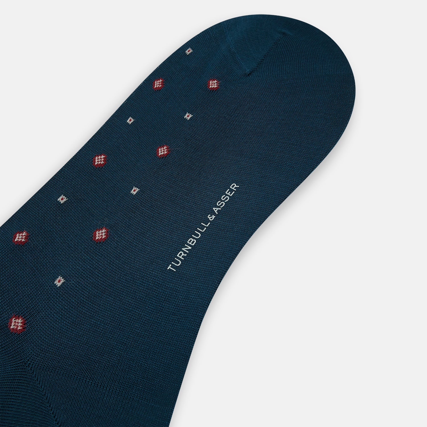 Image 3 of product The Turnbull & Asser Azzurro Patterned Mid-Length Sock is navy blue with a ribbed cuff and features a small red and white diamond motif, shown here individually against a plain white background.