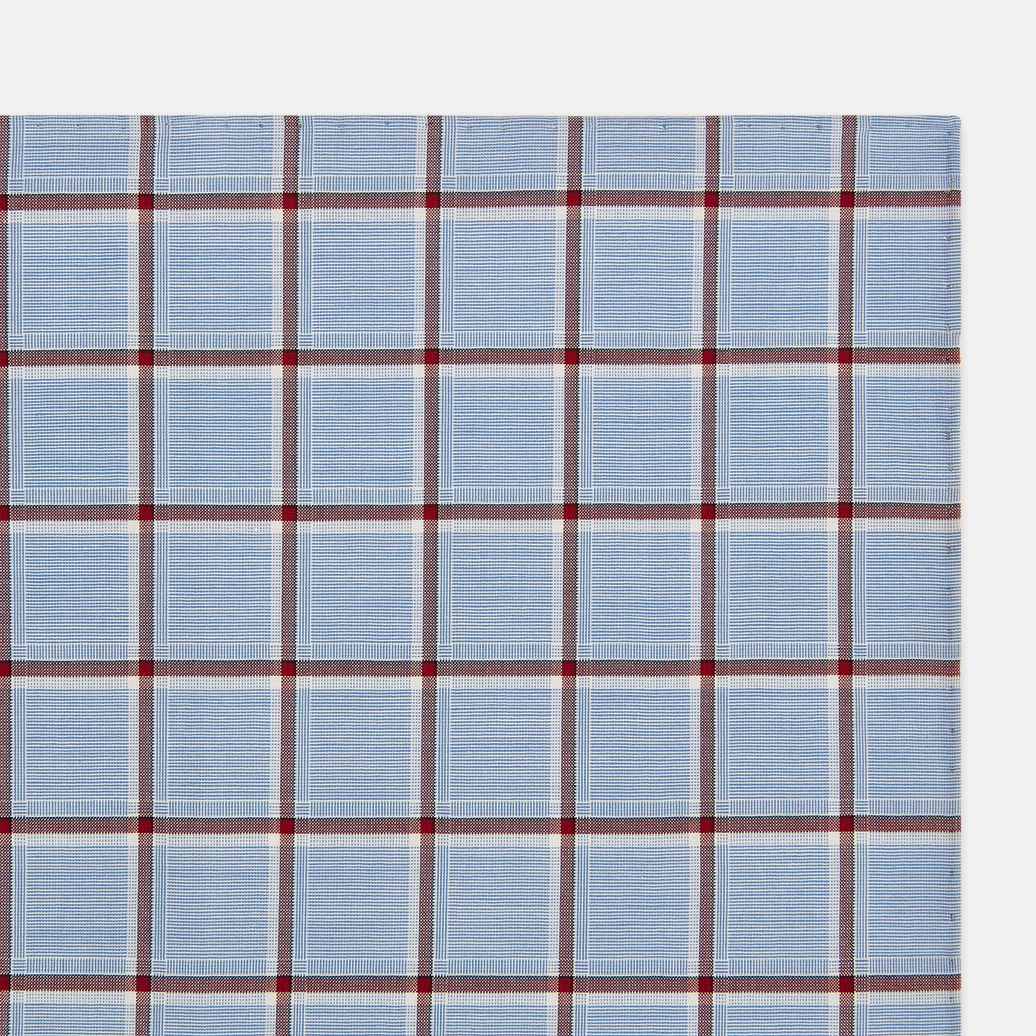 Image 3 of product The Turnbull & Asser Blue and Burgundy Windowpane Check Hand-Rolled Handkerchief features a light blue fabric with white, red, and dark blue stripes forming a classic plaid grid.