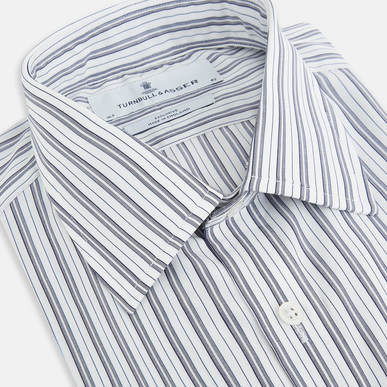 Image 2 of product The Turnbull & Asser Navy Multi Stripe Mayfair Shirt, a pure cotton button-up with long sleeves and a collar, features thin vertical blue and white stripes and is displayed flat on a white background.