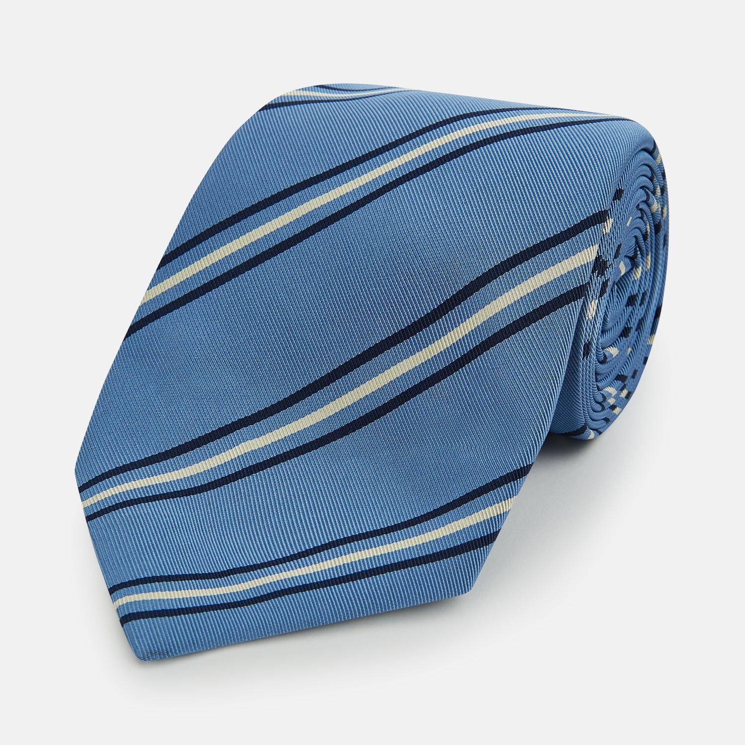 Image 1 of product The Blue Multi Stripe Silk Blend Tie by Turnbull & Asser features diagonal navy and light beige stripes, shown rolled up on a white background—a timeless formal accessory.