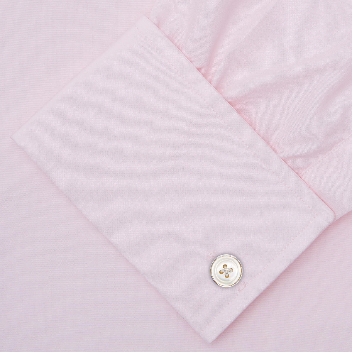 Image 3 of product A neatly folded Pink Cotton Shirt with T&A collar and double cuffs by Turnbull & Asser, featuring a classic design with white buttons and an inner label, displayed on a plain white background.