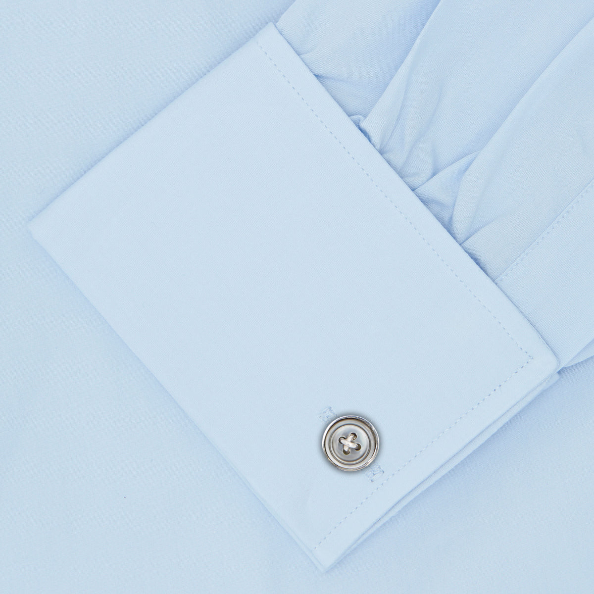 Image 3 of product The Turnbull & Asser Light Blue Sea Island Quality Cotton Shirt features a T&A collar, double cuffs, white buttons, and a quality label inside the collar. Displayed on a plain white background.