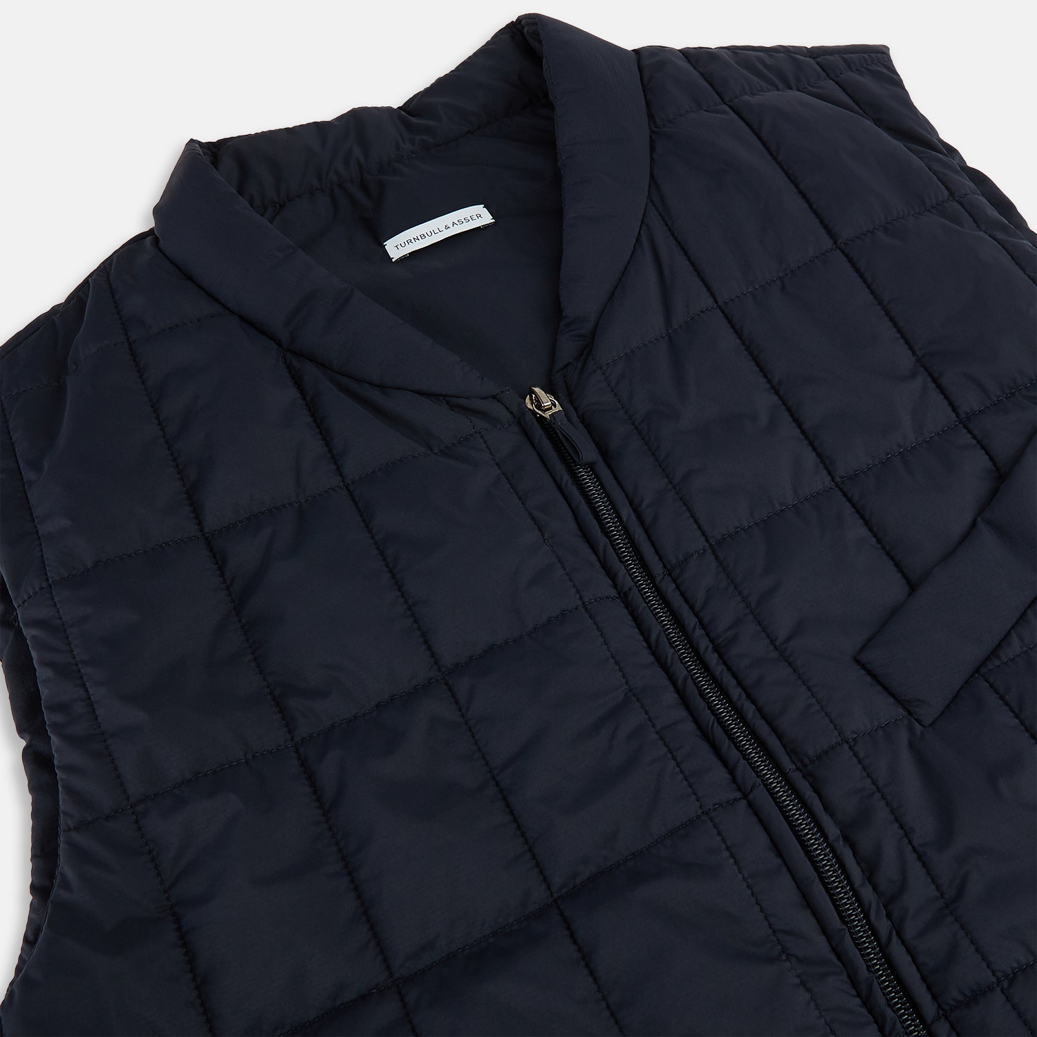 Image 2 of product The Turnbull & Asser Navy Quilted Gilet is sleeveless and lightweight, with a front zipper, zippered side pockets, chest pocket, and rounded hem—ideal for versatile layering. Shown on a plain white background.