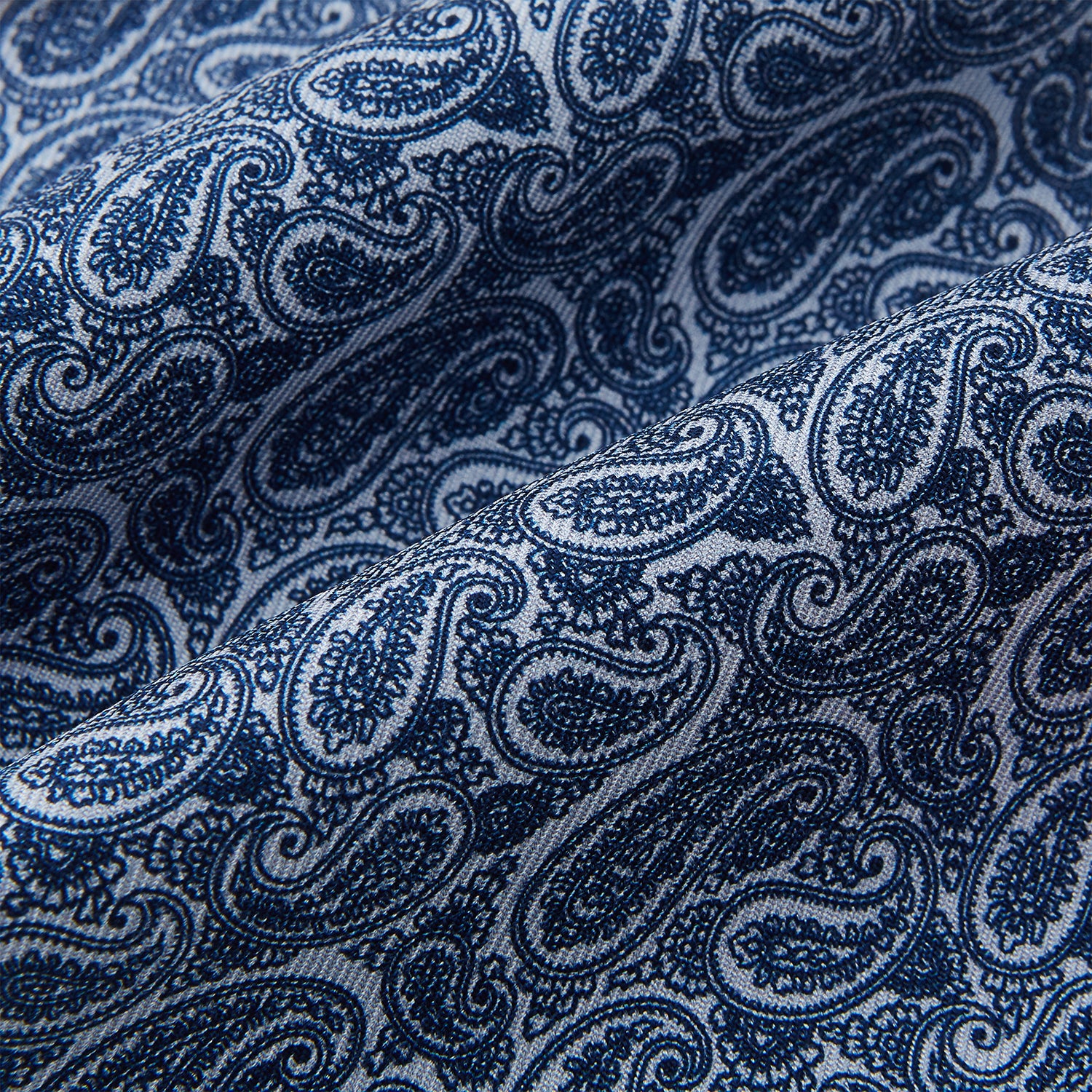 Image 4 of product The Pale Blue Paisley Silk Cravat by Turnbull & Asser showcases intricate, swirling blue and white paisley designs on a light background, echoing the elegance of British style accessories.
