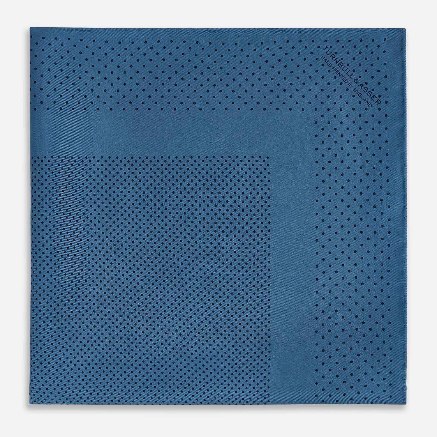 Image 3 of product The Blue Dot Silk Pocket Square by Turnbull & Asser features small black polka dots on blue silk and is made in England. The image shows it neatly folded, with a corner turned down to display both sides.