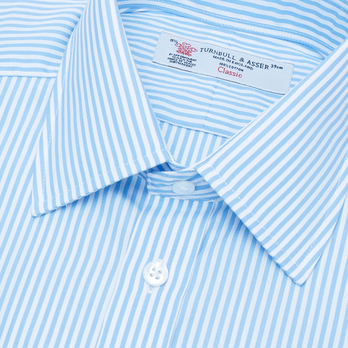 Image 2 of product The Turnbull & Asser Light Blue Bengal Stripe Shirt features a classic T&A collar, double cuffs, and white buttons. Made from cotton with blue and white stripes, it's neatly displayed against a plain white background.