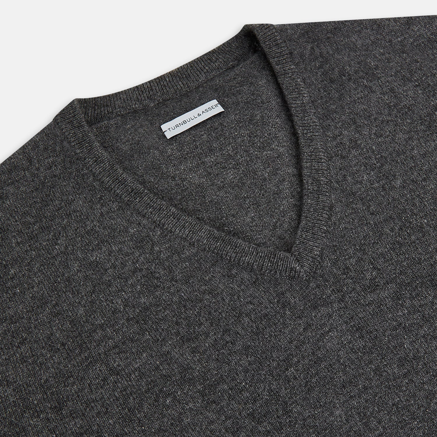Image 2 of product The Charcoal Grey Cashmere V-neck Jumper by Turnbull & Asser features ribbed cuffs, hem, and neckline—an essential knitwear piece, shown on a white background.