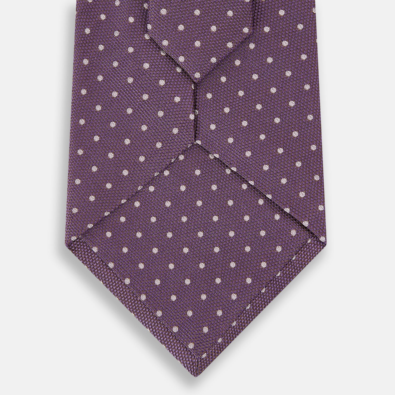Image 3 of product The Turnbull & Asser Lilac and Purple Micro Dot Silk Tie, featuring small white dots, is a stylish accessory for smart attire. Displayed rolled-up on a light background.