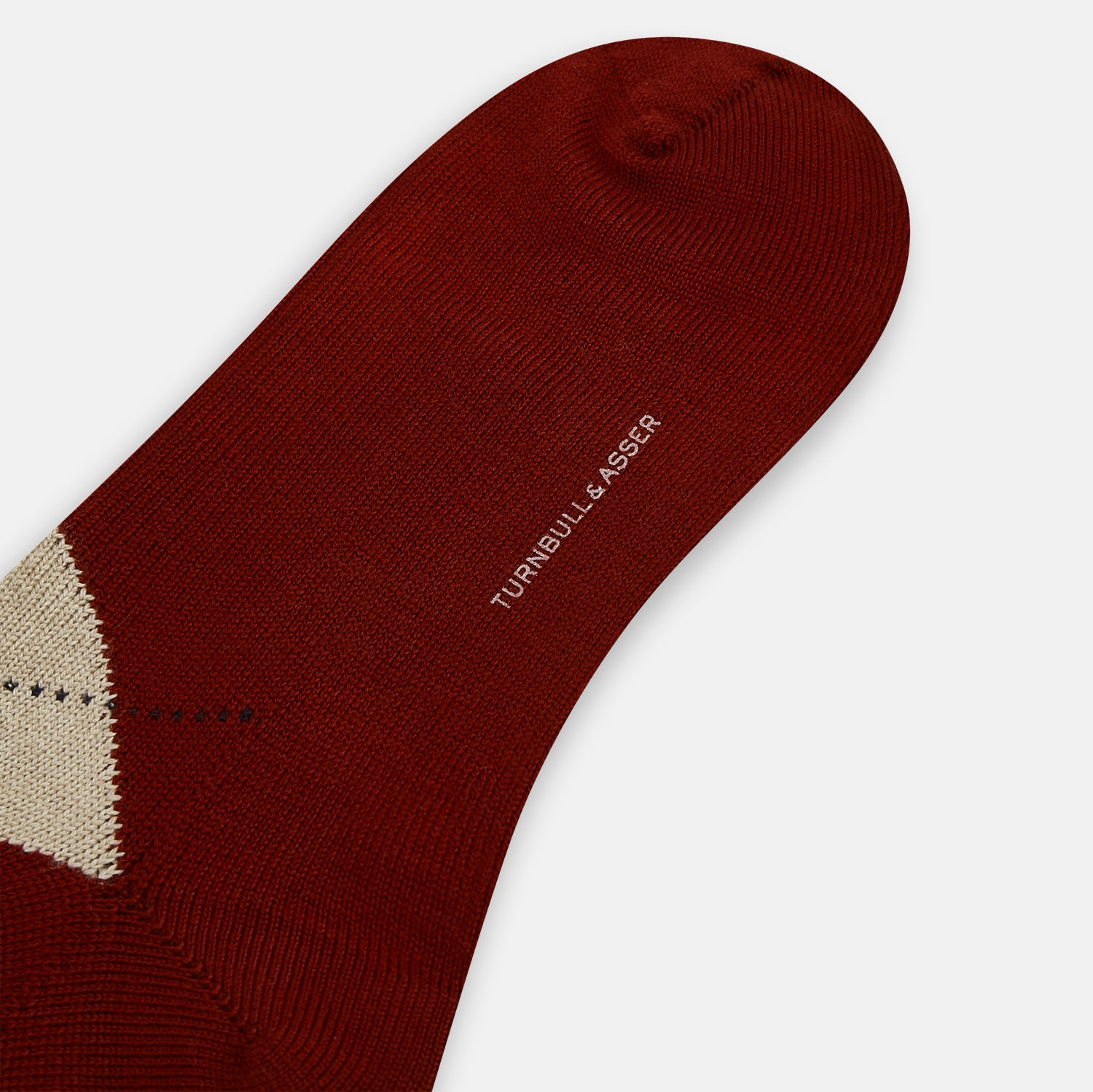 Image 3 of product The Turnbull & Asser Burgundy Wool Check Mid-Length Sock features a dark red base with beige, white, and light brown argyle diamonds on the calf, shown against a plain white background.