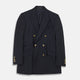 The Classic Navy Wool Blazer by Turnbull & Asser features a double-breasted design, gold buttons, notched lapels, and multiple front pockets, shown on a white background. This piece offers timeless, sophisticated nautical style.