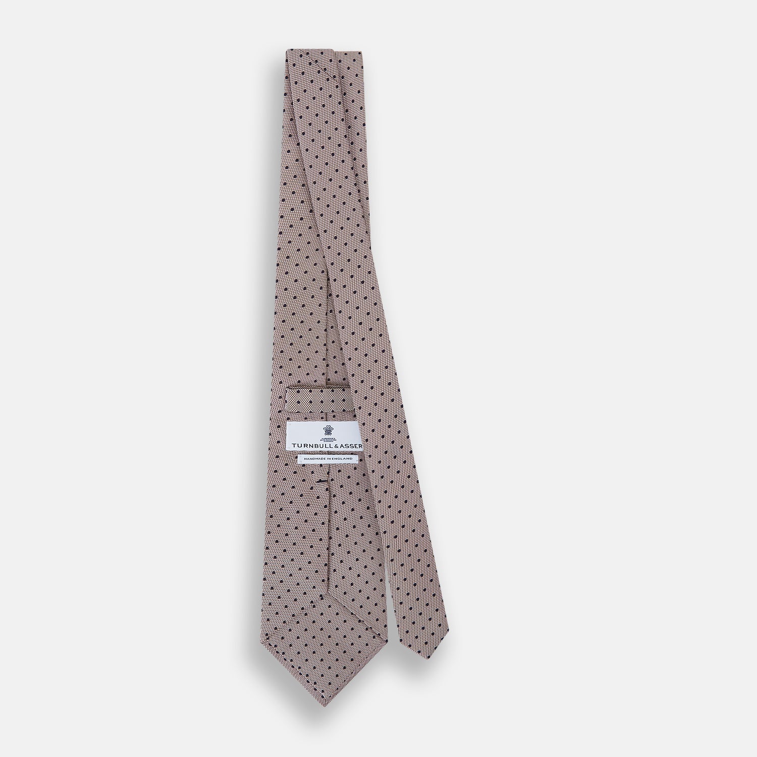 Image 4 of product The Turnbull & Asser Navy and Lilac Micro Dot Silk Tie, featuring subtle micro dots, is the perfect refined accessory for smart outfits, shown rolled up against a plain white background.
