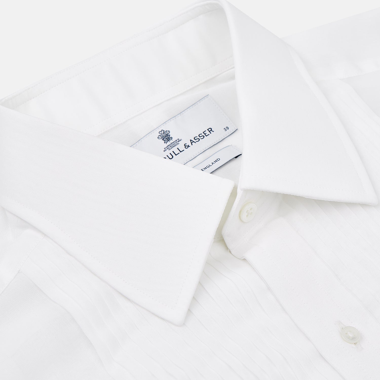 Image 8 of product The Die Another Day Inspired Voile Dress Shirt by Turnbull & Asser features a white pleated front, button-down closure, and classic collar—laid flat on white to showcase its timeless James Bond style.