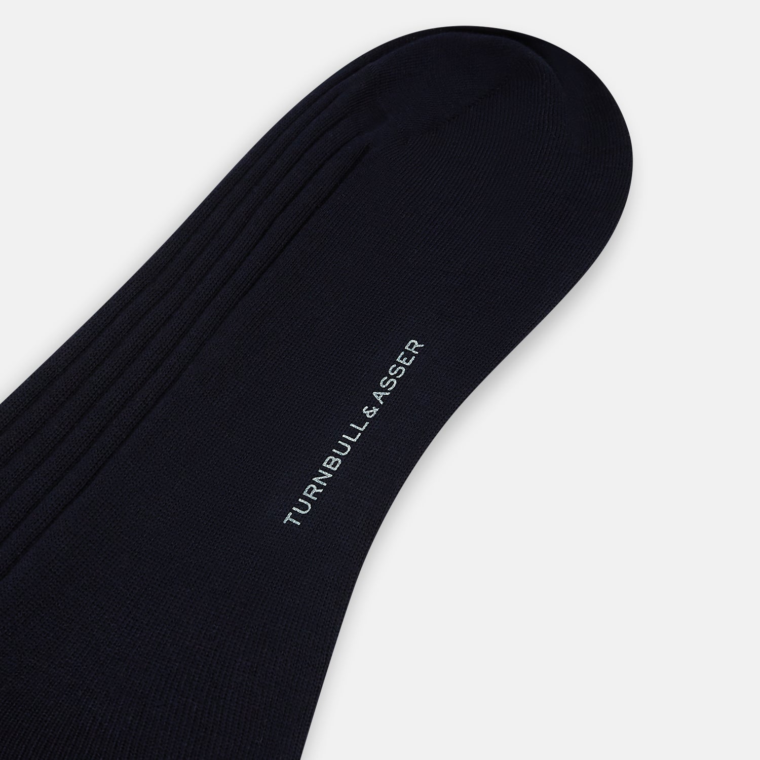 Image 3 of product A single navy mid-length sock by Turnbull & Asser, crafted from organic cotton with a ribbed texture, stands upright on a white background.