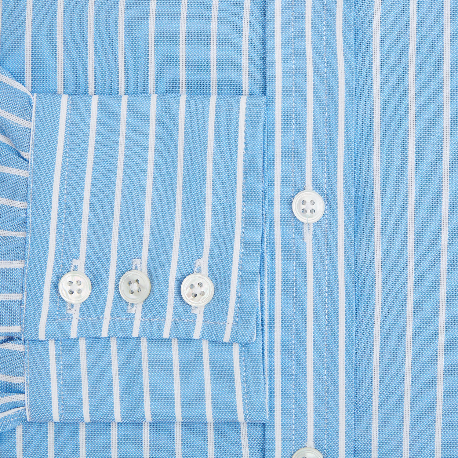 Image 4 of product The Turnbull & Asser Sky Blue Wide Pinstripe Mayfair Shirt features long sleeves, a classic collar, and buttoned cuffs, laid flat against a white background for a refined formal look.