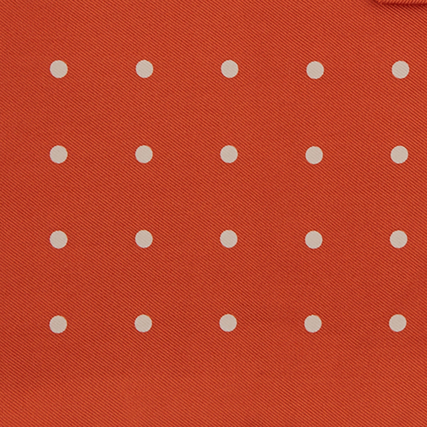 Image 3 of product The Orange Spot Silk Pocket Square by Turnbull & Asser features evenly spaced white polka dots and the brand’s name in one corner, making this dapper accessory a standout addition to any outfit.