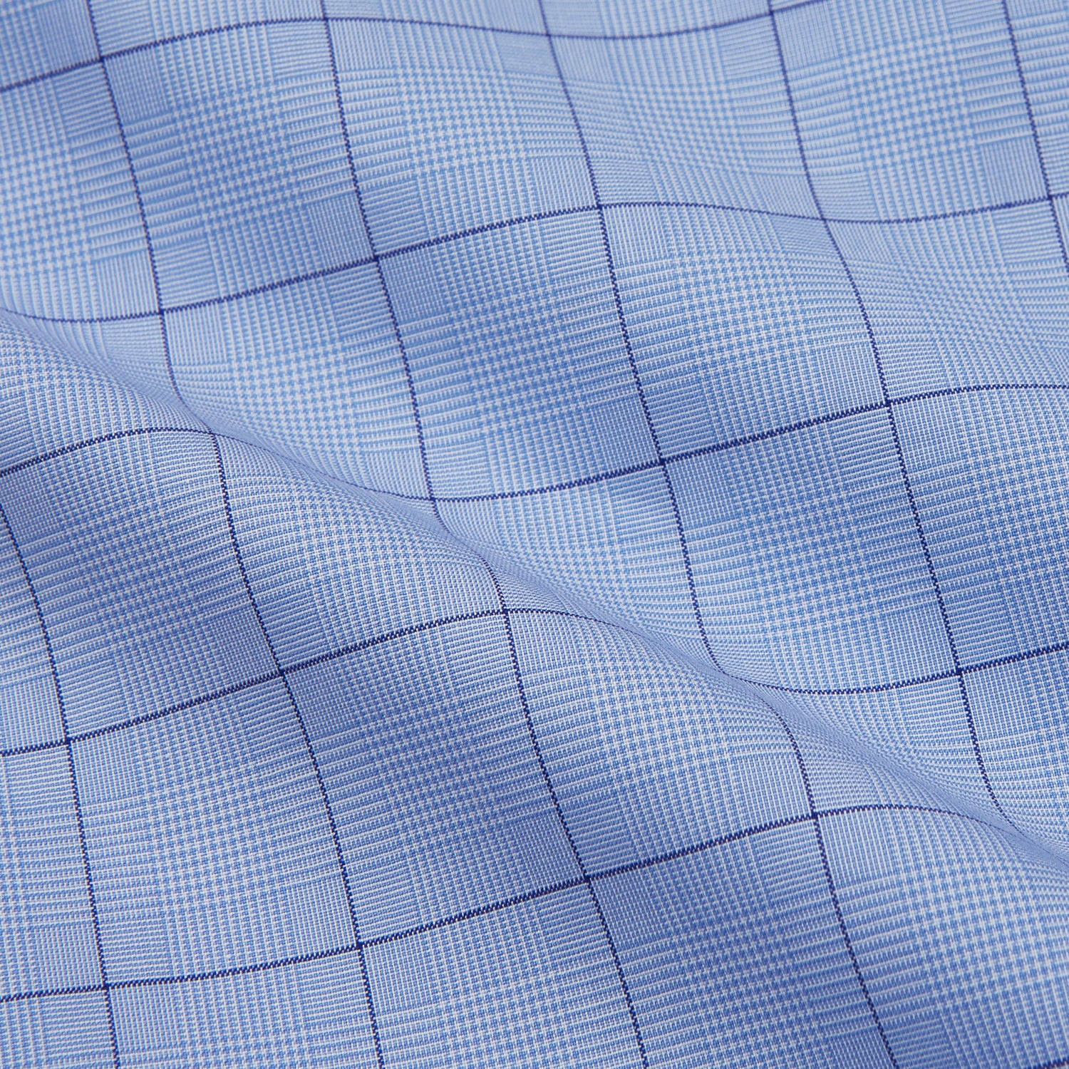 Image 5 of product The Blue Prince of Wales Check Mayfair Shirt by Turnbull & Asser is a light blue formal long-sleeve shirt with a subtle check pattern, button-down front, and buttoned cuffs, shown laid flat on a white background.