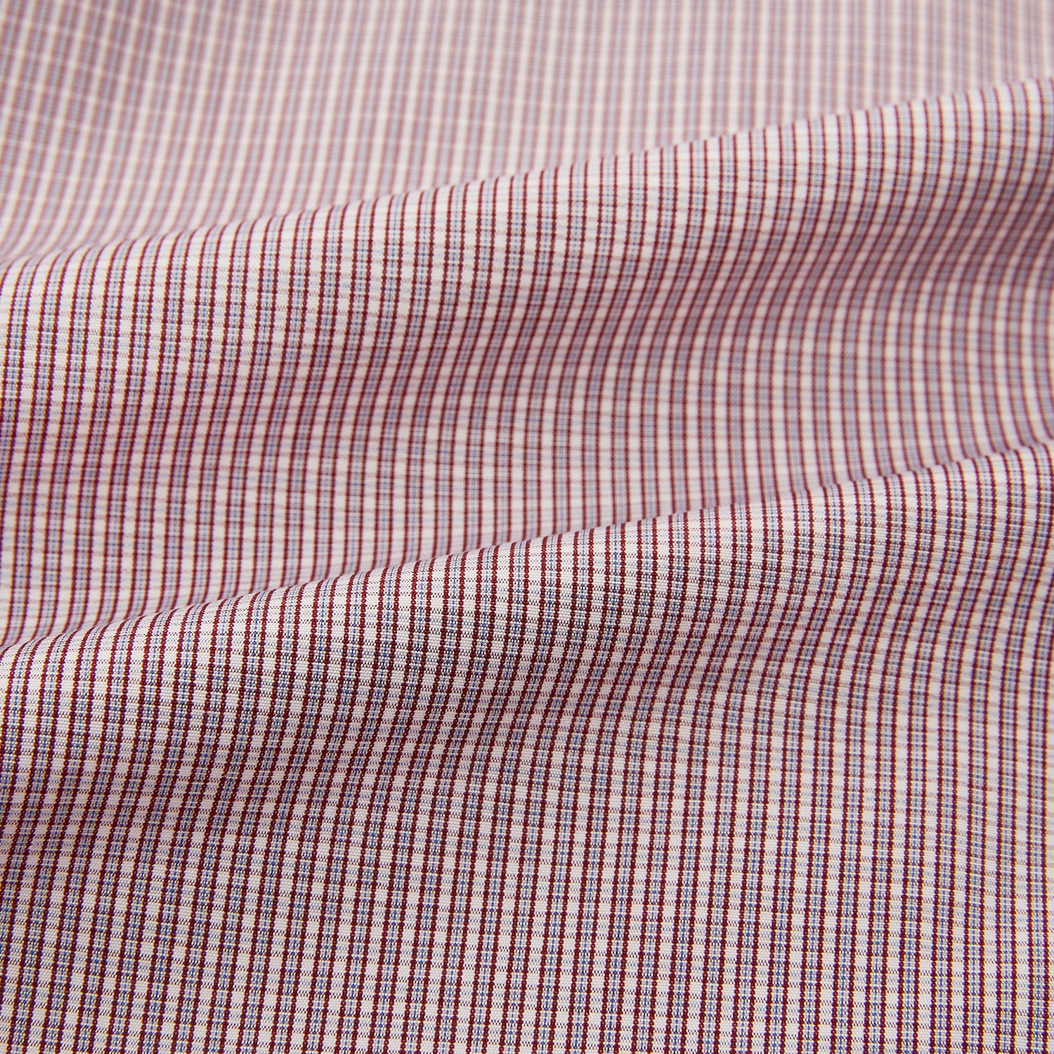 Image 6 of product The Turnbull & Asser Burgundy Micro Shadow Check Mayfair Shirt features long sleeves, a classic collar, and white buttons. In light red and white shades, this button-up is perfect for formal wear and is shown laid flat against a white background.