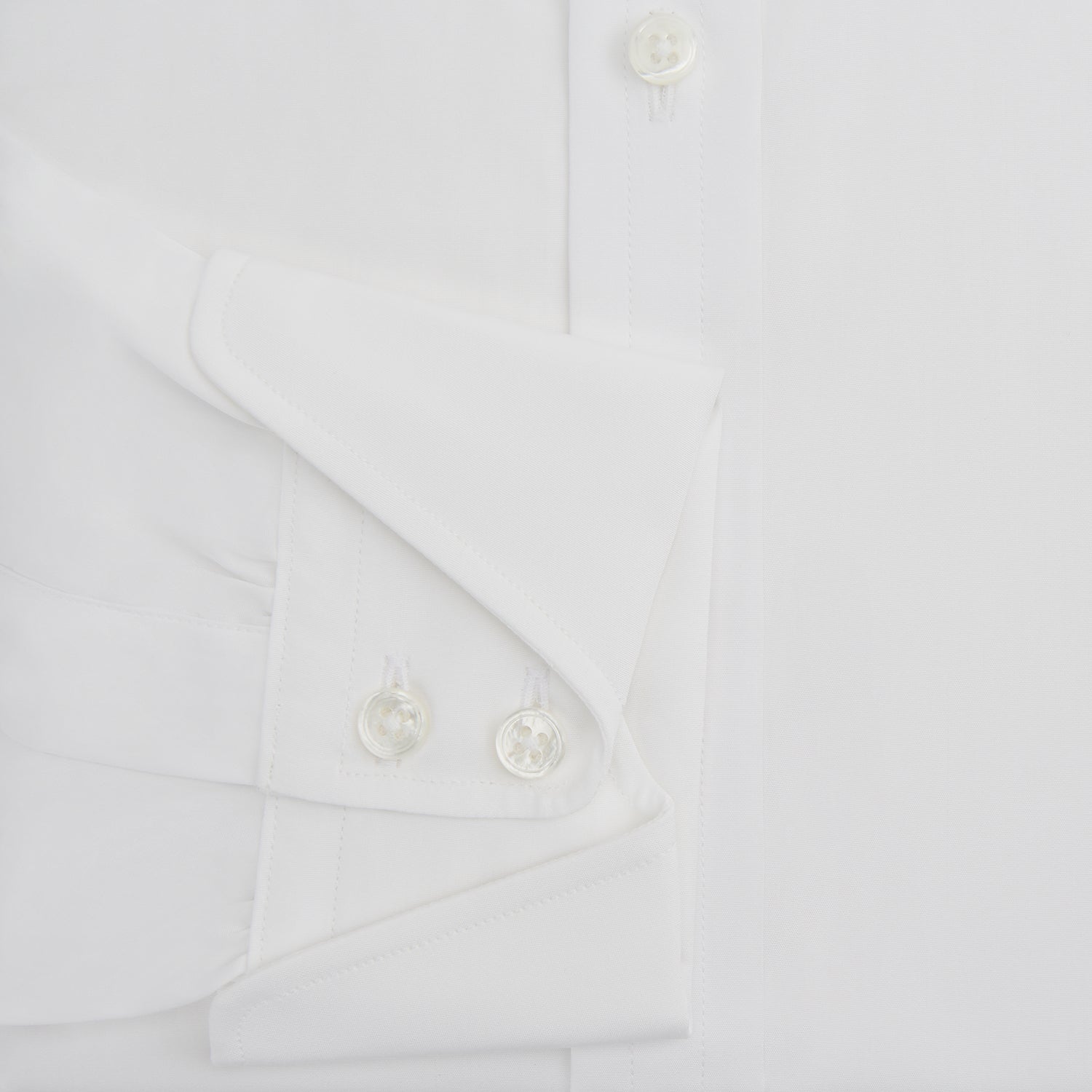 Image 4 of product The Turnbull & Asser White Poplin Shirt With Regent Collar and 2-Button Cocktail Cuffs, featuring long sleeves, is buttoned up and laid flat on a white background.