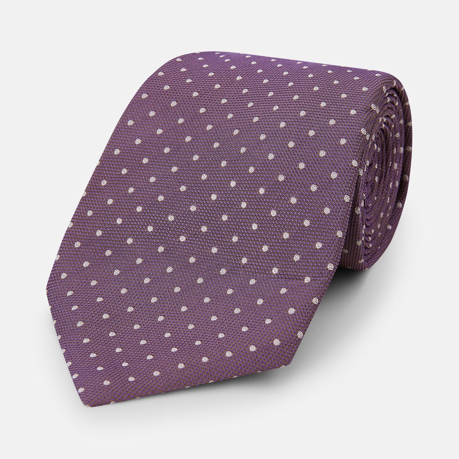 Image 1 of product The Turnbull & Asser Lilac and Purple Micro Dot Silk Tie, featuring small white dots, is a stylish accessory for smart attire. Displayed rolled-up on a light background.