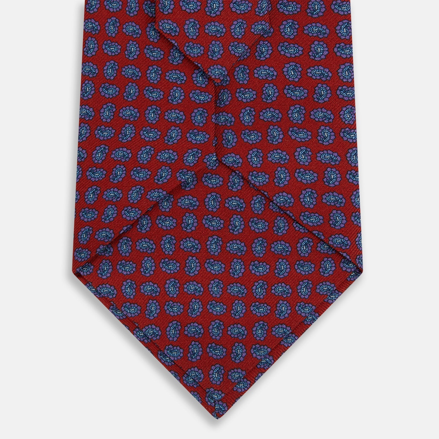 Image 3 of product The Turnbull & Asser Red and Purple Miniature Paisley Silk Tie is neatly rolled with the pointed end facing forward.