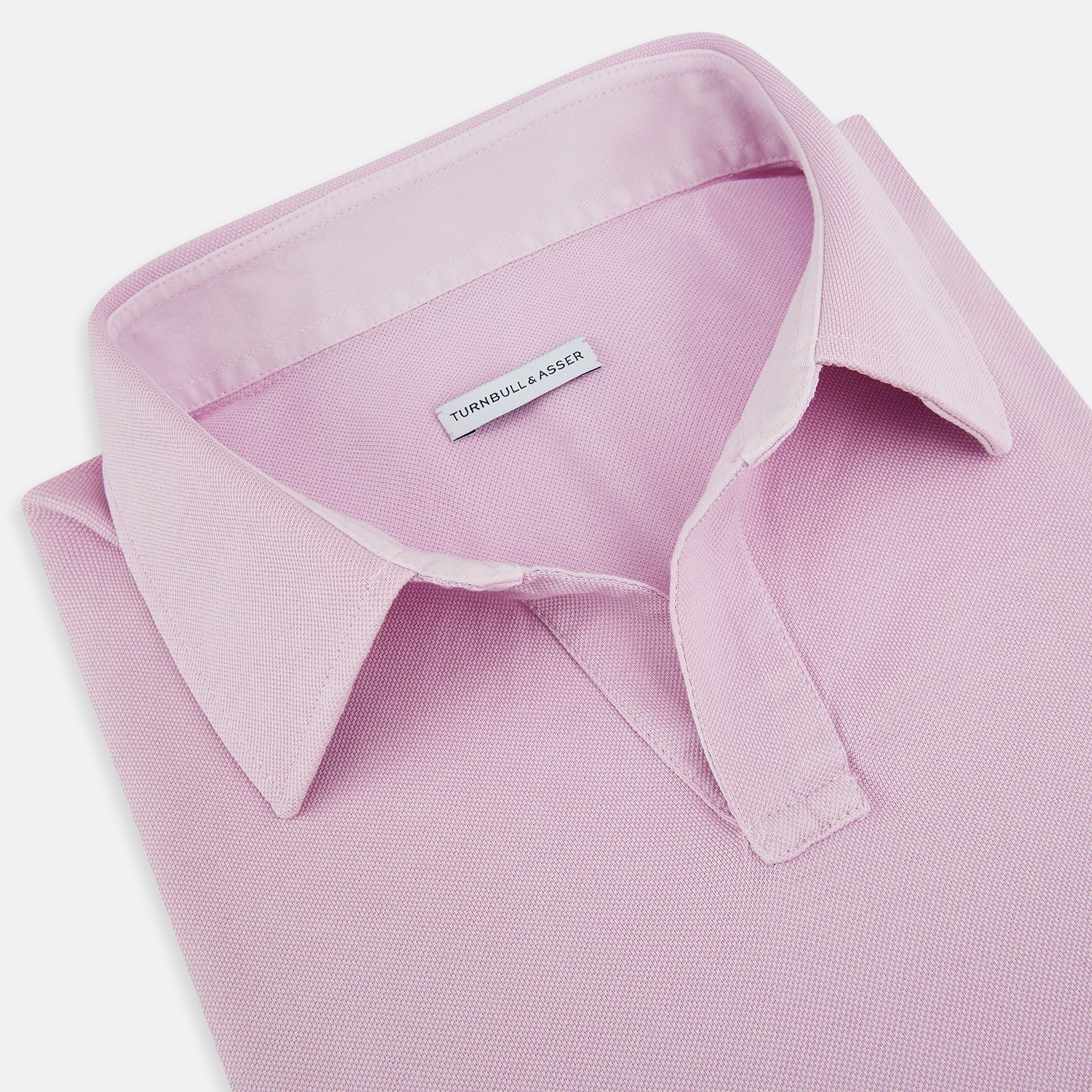 Image 2 of product The Pink Rugby Polo Shirt by Turnbull & Asser features long sleeves, a collar, and V-neck opening in luxury cotton, shown flat on a white background.