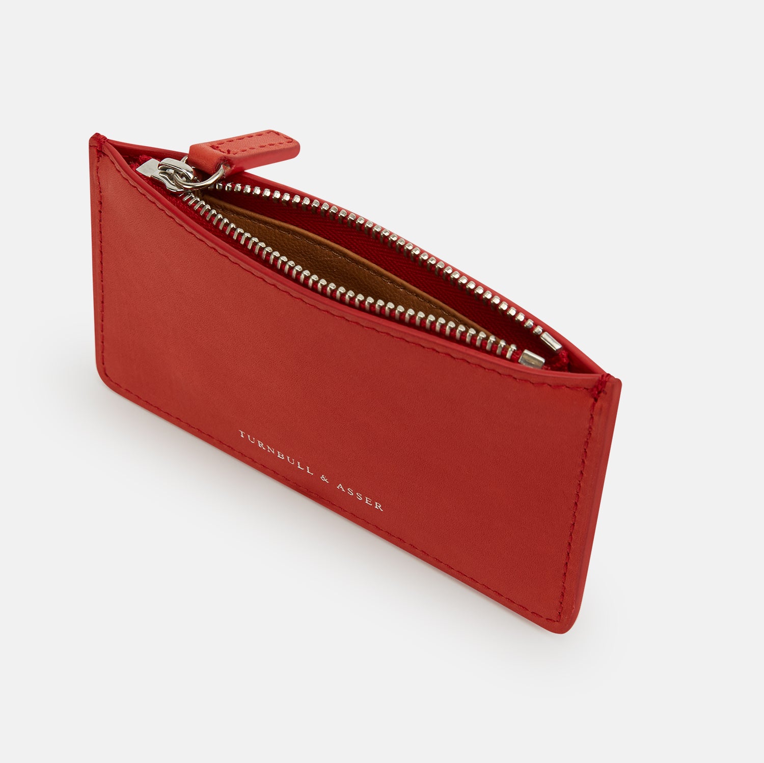 Image 2 of product The Red Leather Zip Wallet by Turnbull & Asser features gold-embossed branding on the front and is shown against a plain white background.