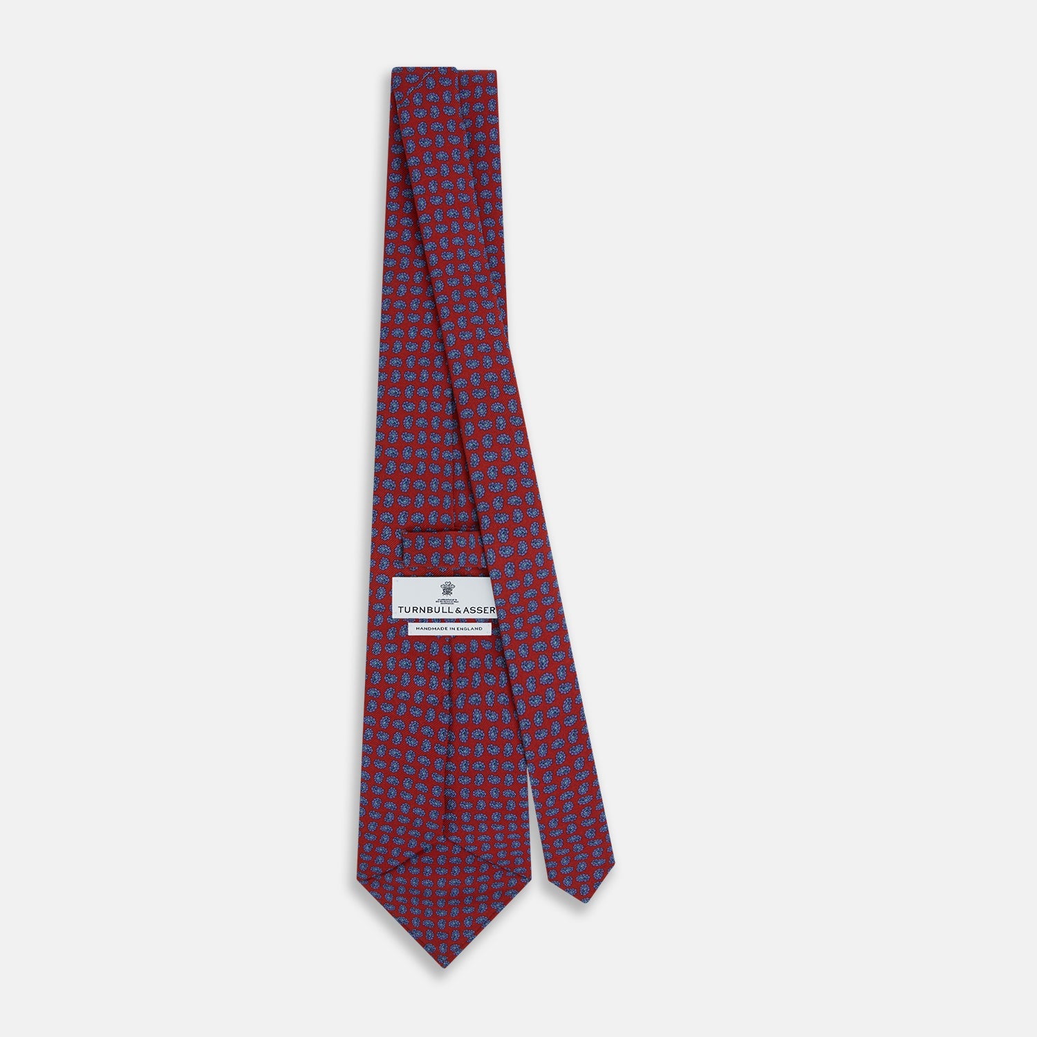 Image 4 of product The Turnbull & Asser Red and Purple Miniature Paisley Silk Tie is neatly rolled with the pointed end facing forward.