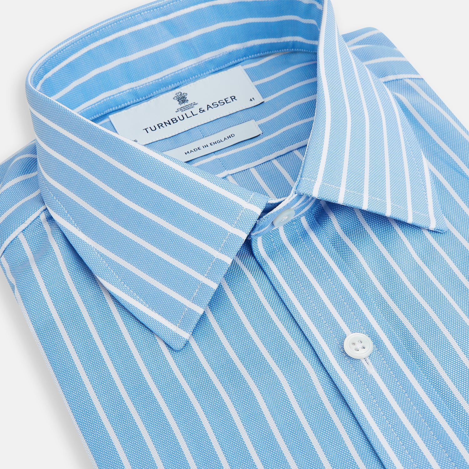 Image 2 of product The Turnbull & Asser Sky Blue Wide Pinstripe Mayfair Shirt features long sleeves, a classic collar, and buttoned cuffs, laid flat against a white background for a refined formal look.