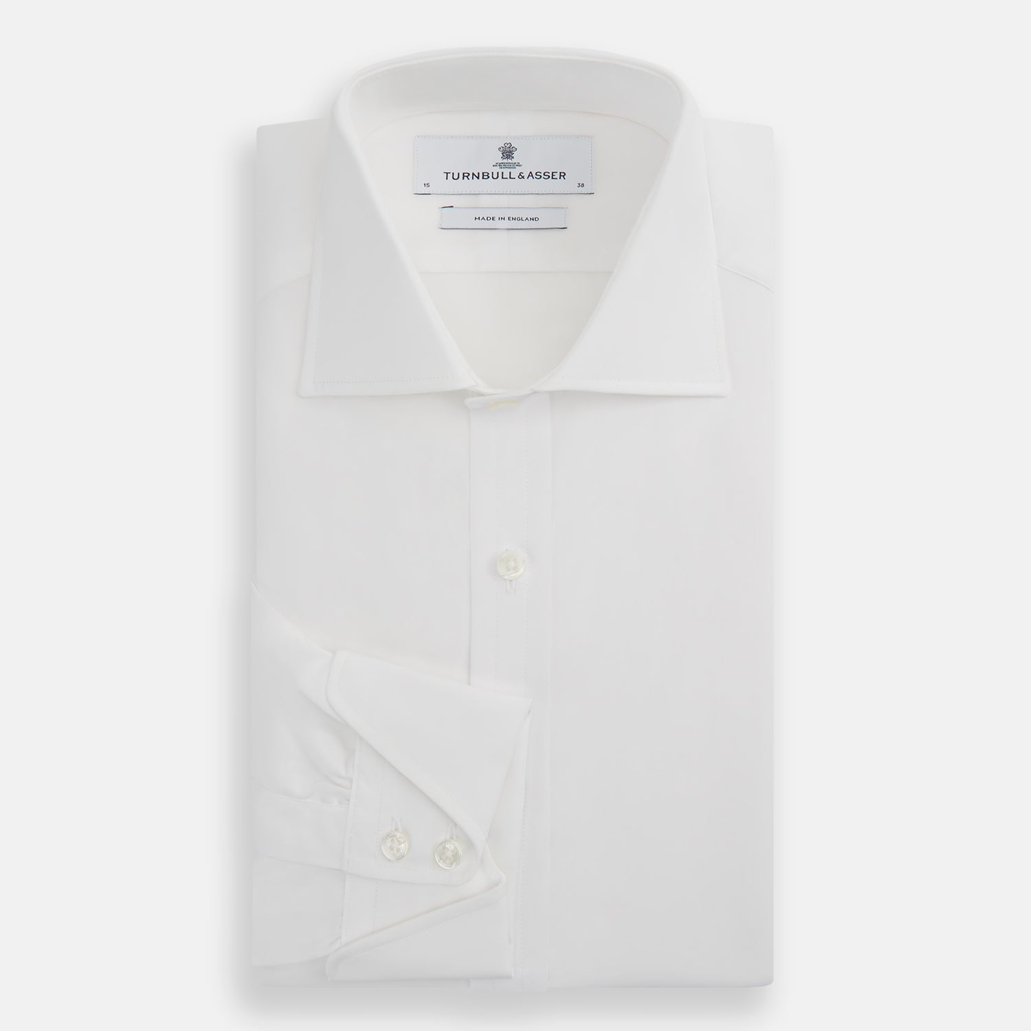 Image 5 of product The Turnbull & Asser White Poplin Shirt With Regent Collar and 2-Button Cocktail Cuffs, featuring long sleeves, is buttoned up and laid flat on a white background.