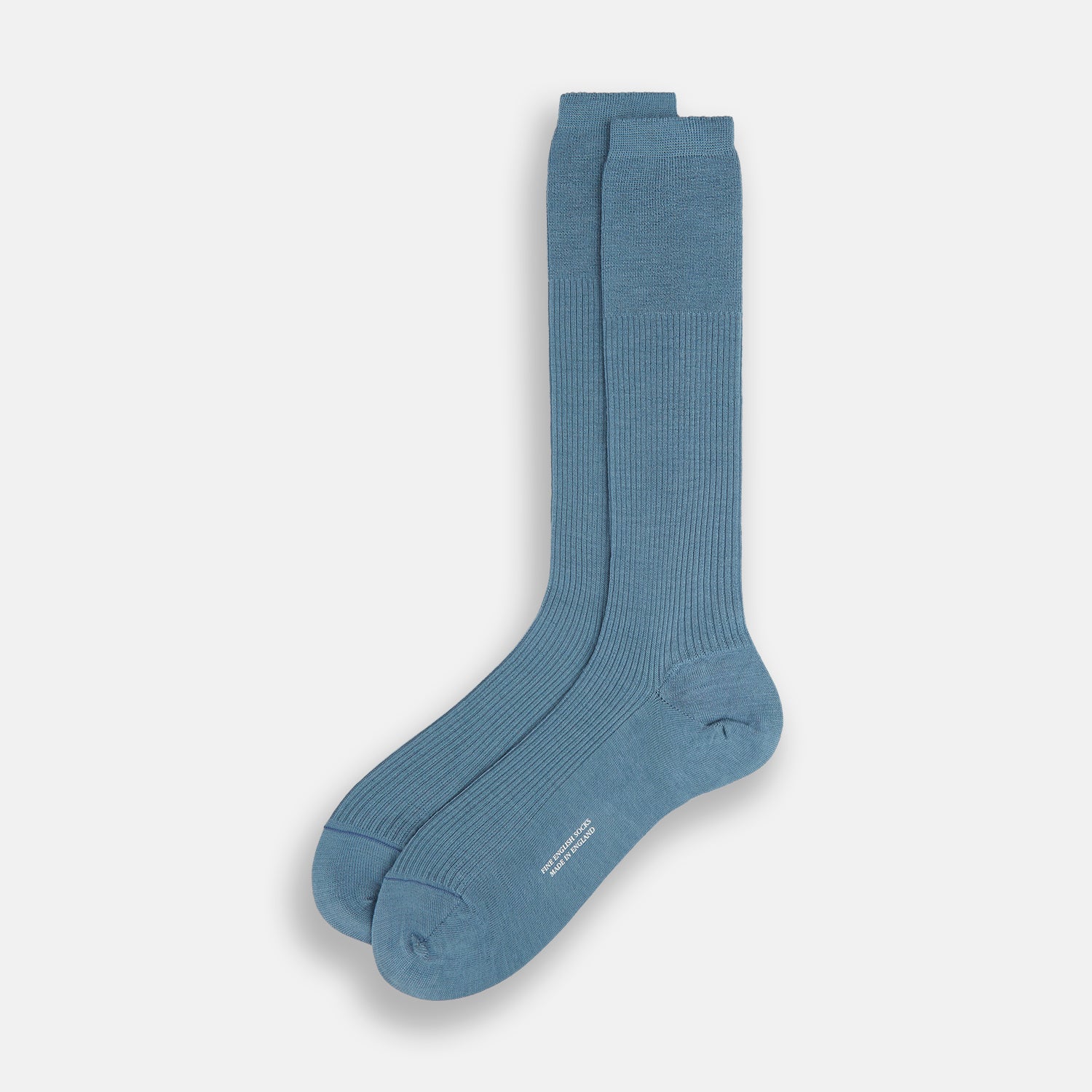 Image 2 of product A single Pale Blue Mid-Length Merino Sock by Turnbull & Asser stands upright against a white background, highlighting its ribbed texture and reinforced toe and heel—showcasing the elegance of luxury merino wool.