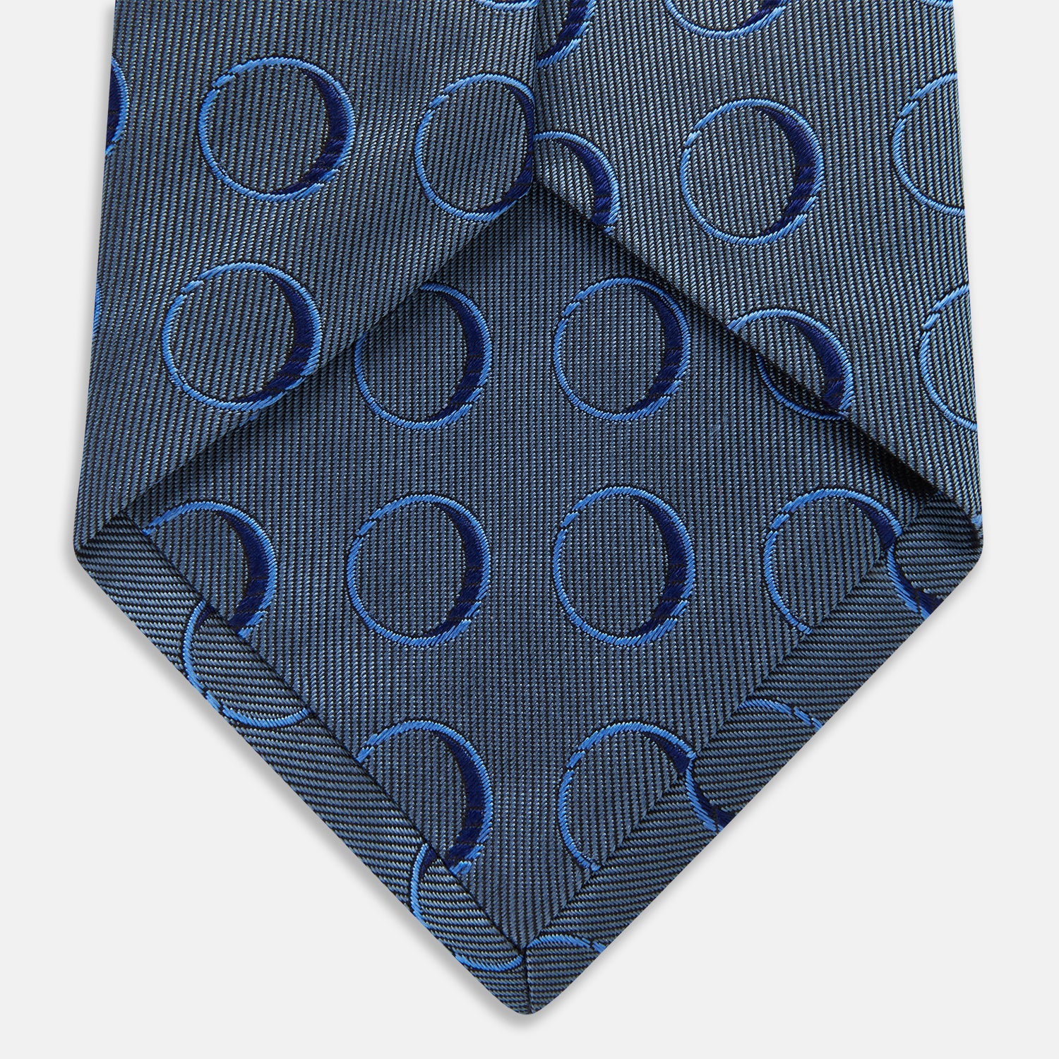 Image 5 of product The Turnbull & Asser Die Another Day Circle Silk Tie, as seen on James Bond, features large dark blue ovals on a lighter blue background.