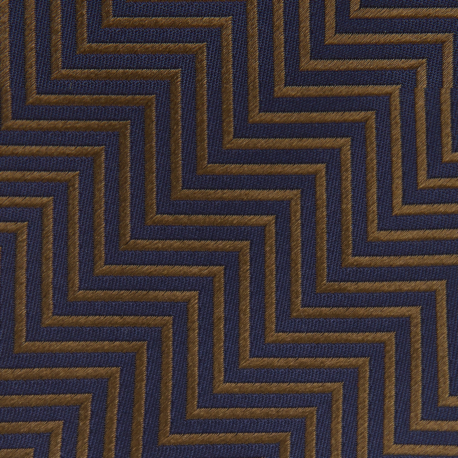 Image 4 of product Turnbull & Asser's "The World Is Not Enough" Zig Zag Silk Tie, as seen on James Bond, features a bold navy blue and gold chevron design and is shown neatly rolled on a white background.