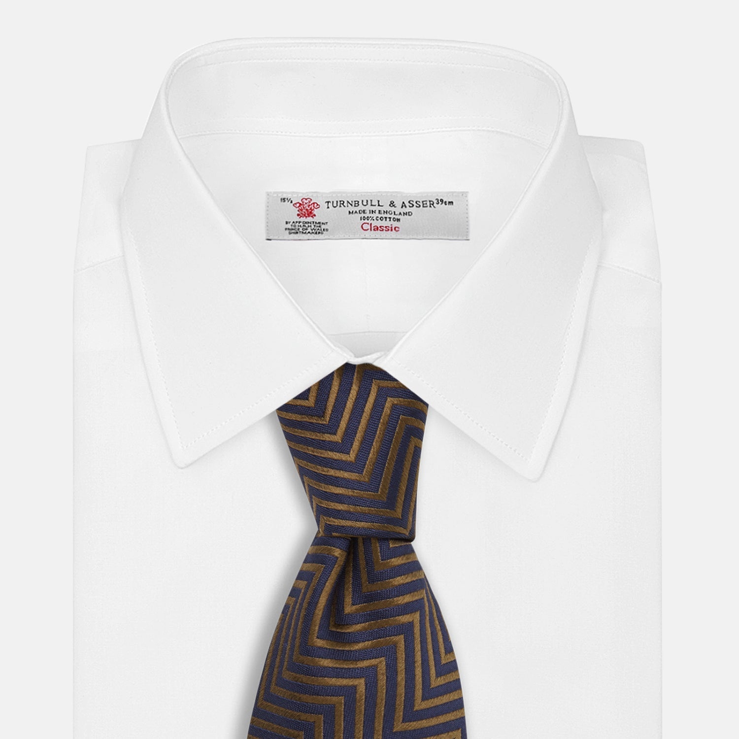 Image 3 of product Turnbull & Asser's "The World Is Not Enough" Zig Zag Silk Tie, as seen on James Bond, features a bold navy blue and gold chevron design and is shown neatly rolled on a white background.