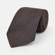 Turnbull & Asser's "The World Is Not Enough" Zig Zag Silk Tie, as seen on James Bond, features a bold navy blue and gold chevron design and is shown neatly rolled on a white background.