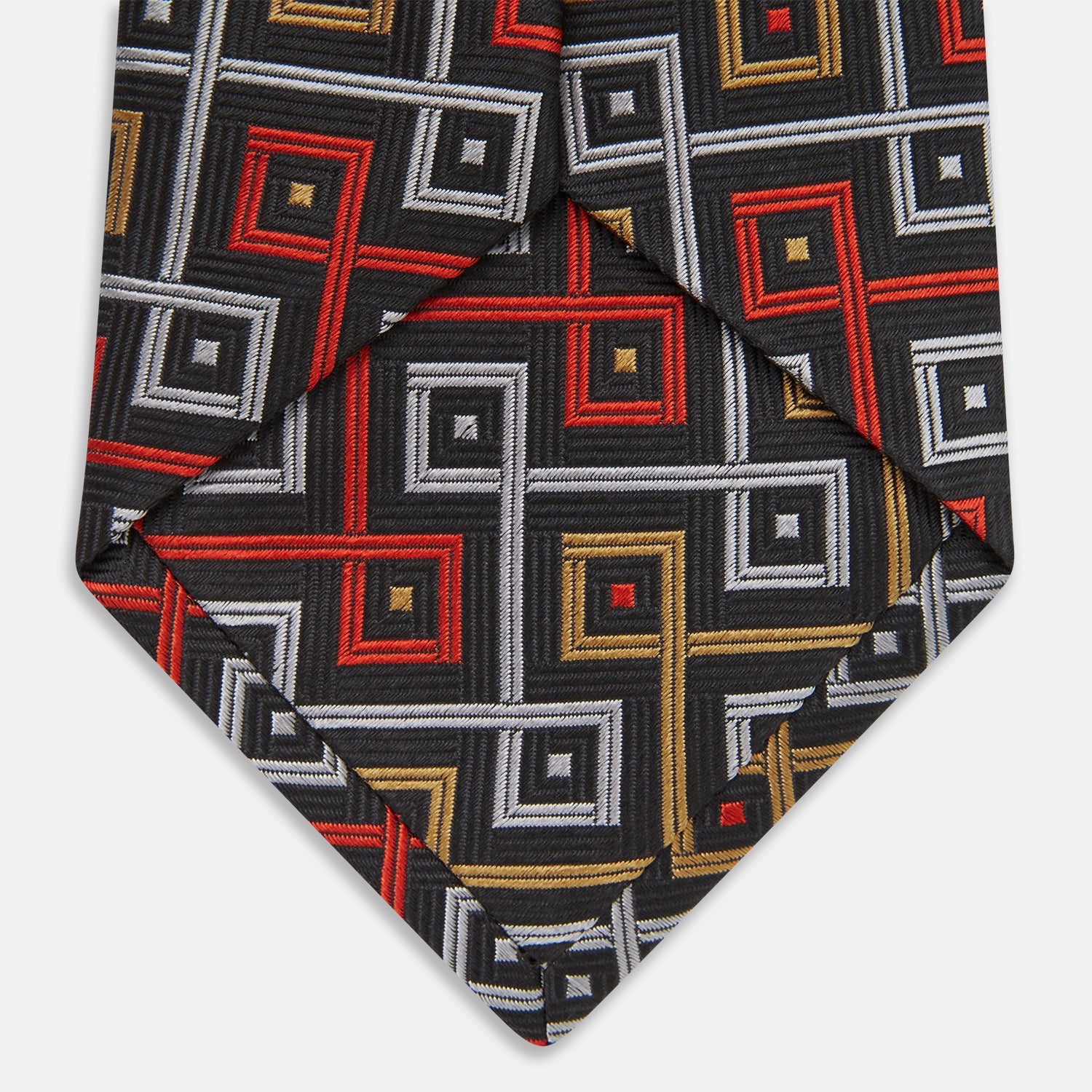 Image 5 of product The Turnbull & Asser "The World Is Not Enough" Square Silk Tie, as seen on James Bond, features a geometric diamond pattern in black, red, yellow, and white on gray—an ideal stylish gift for any Bond fan.