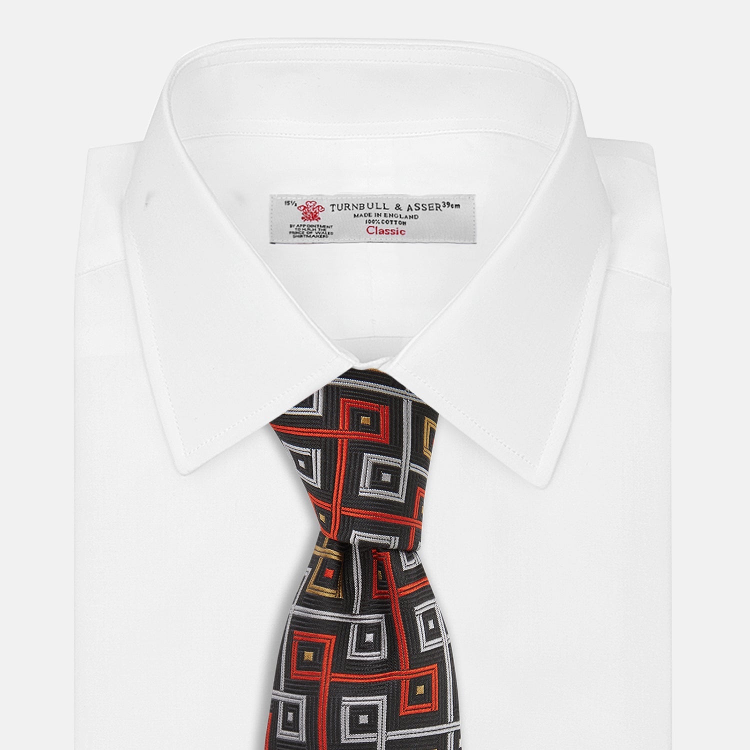 Image 3 of product The Turnbull & Asser "The World Is Not Enough" Square Silk Tie, as seen on James Bond, features a geometric diamond pattern in black, red, yellow, and white on gray—an ideal stylish gift for any Bond fan.