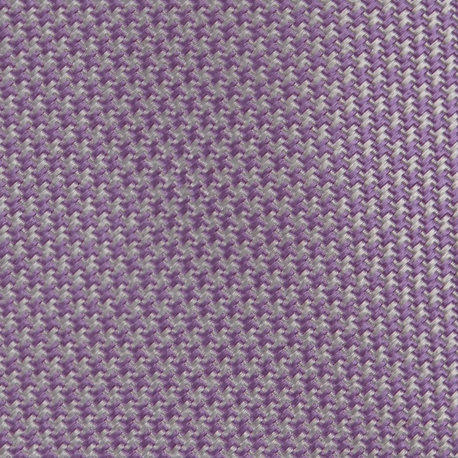 Image 3 of product The Turnbull & Asser Lilac Houndstooth Silk Tie features a subtle houndstooth pattern and elegant silk weave—ideal for elevating your favorite office shirt. Displayed rolled on a white background.