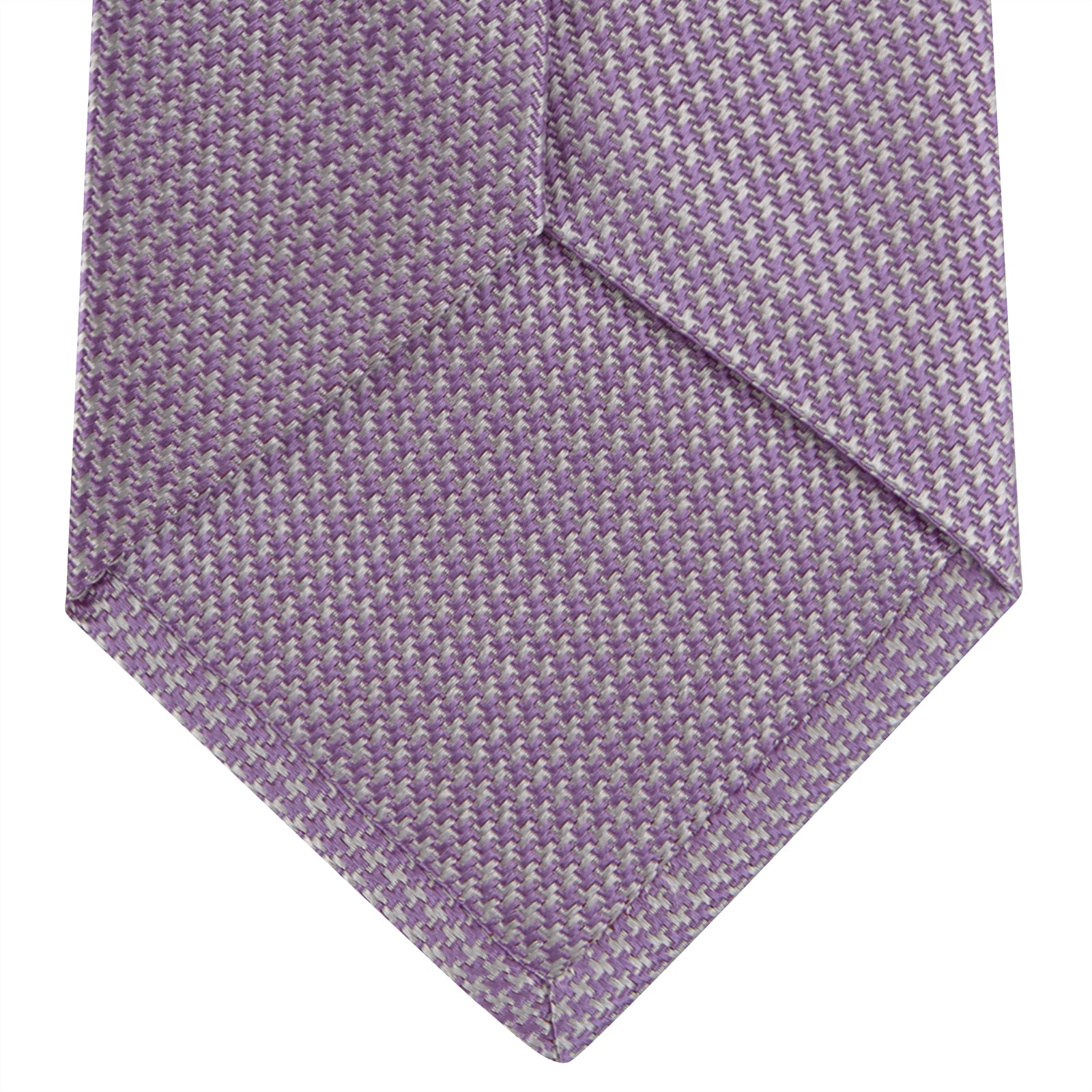 Image 4 of product The Turnbull & Asser Lilac Houndstooth Silk Tie features a subtle houndstooth pattern and elegant silk weave—ideal for elevating your favorite office shirt. Displayed rolled on a white background.