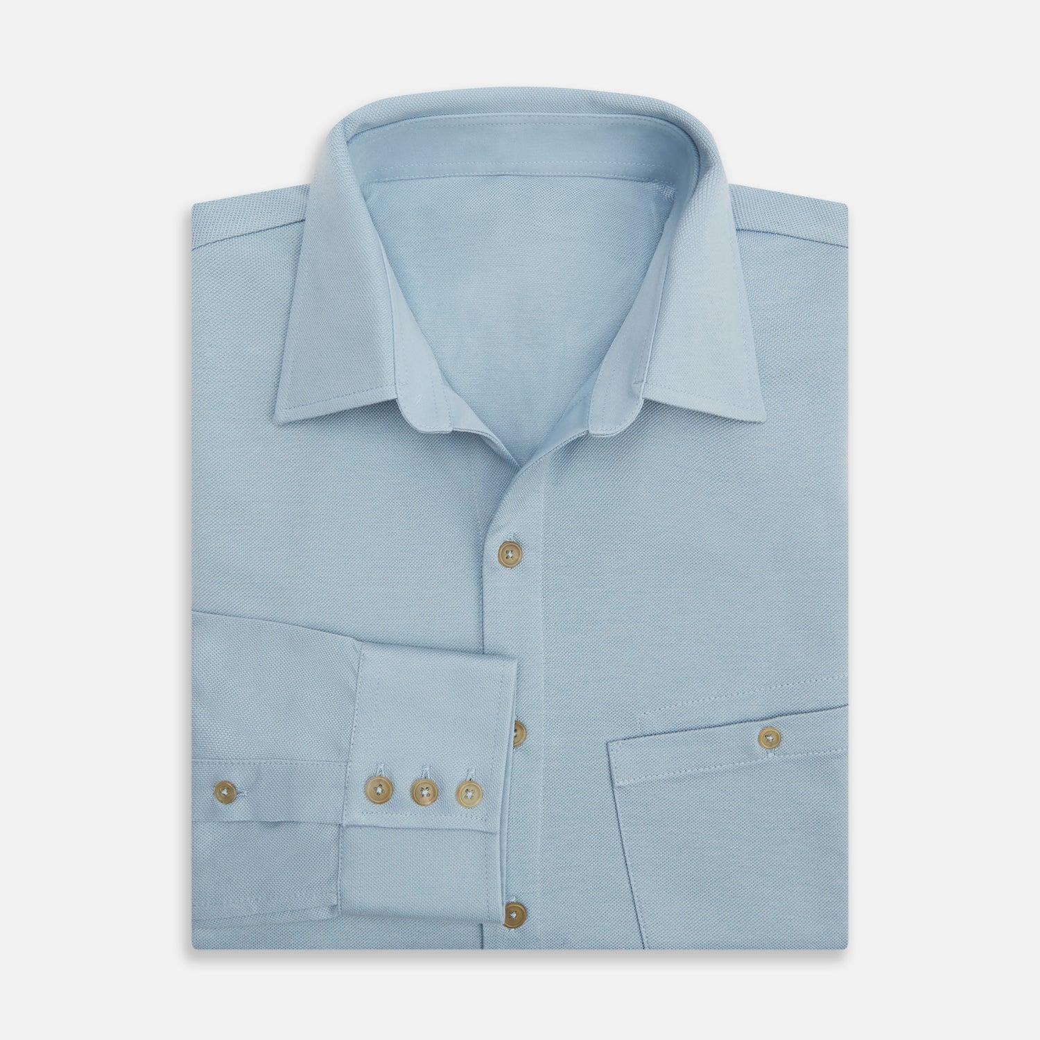 Image 5 of product The Turnbull & Asser Pale Blue Pique Shirt is a long-sleeve button-up with an open collar, single chest pocket, and beige buttons, shown against a white background.