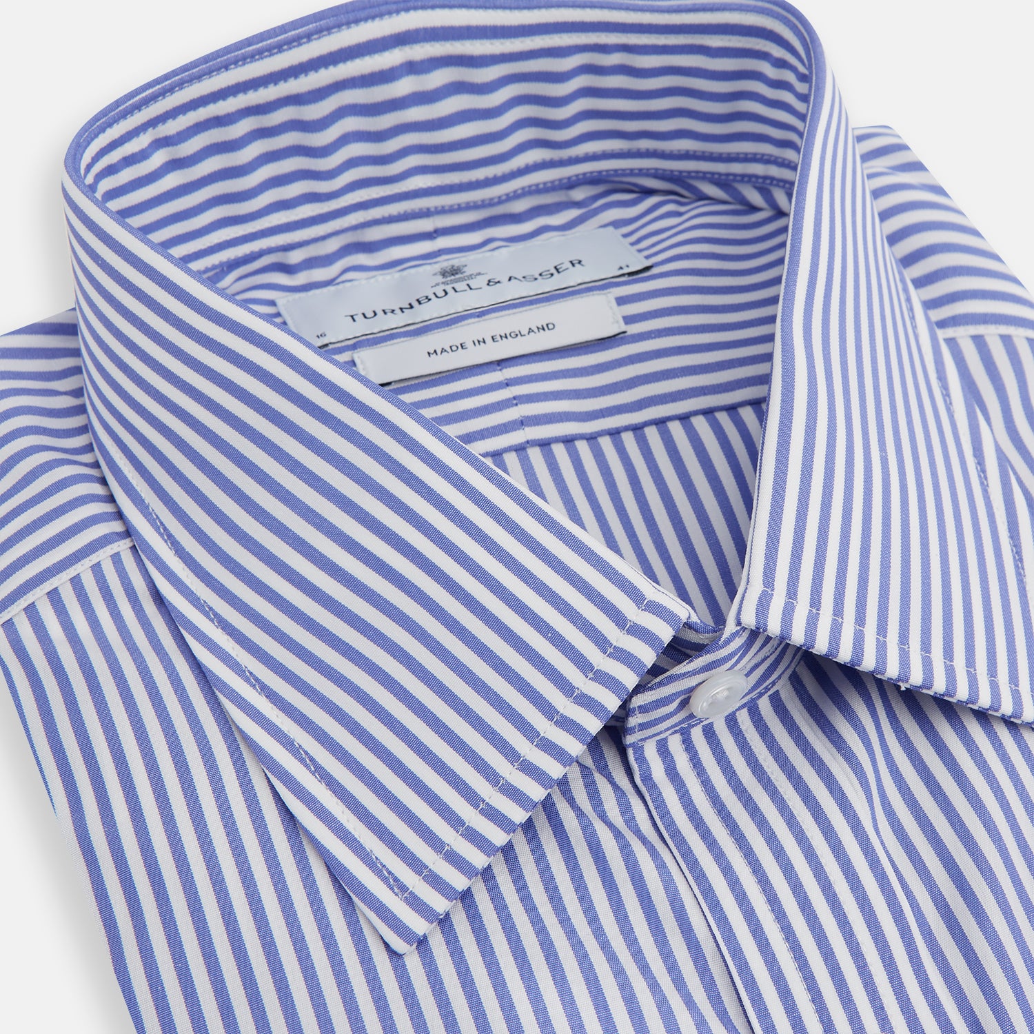 Image 2 of product The Turnbull & Asser Blue Bengal Stripe Shirt features a T&A collar, 3-button cuffs, and classic blue and white vertical stripes, shown neatly laid flat against a white background.
