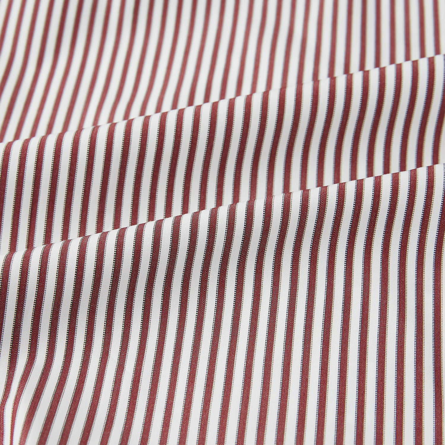Image 6 of product The Turnbull & Asser Burgundy Halo Stripe Winston Shirt features long sleeves, a classic T&A collar, buttoned cuffs, narrow vertical burgundy and white stripes, and is crafted from organic cotton. Displayed on a white background.