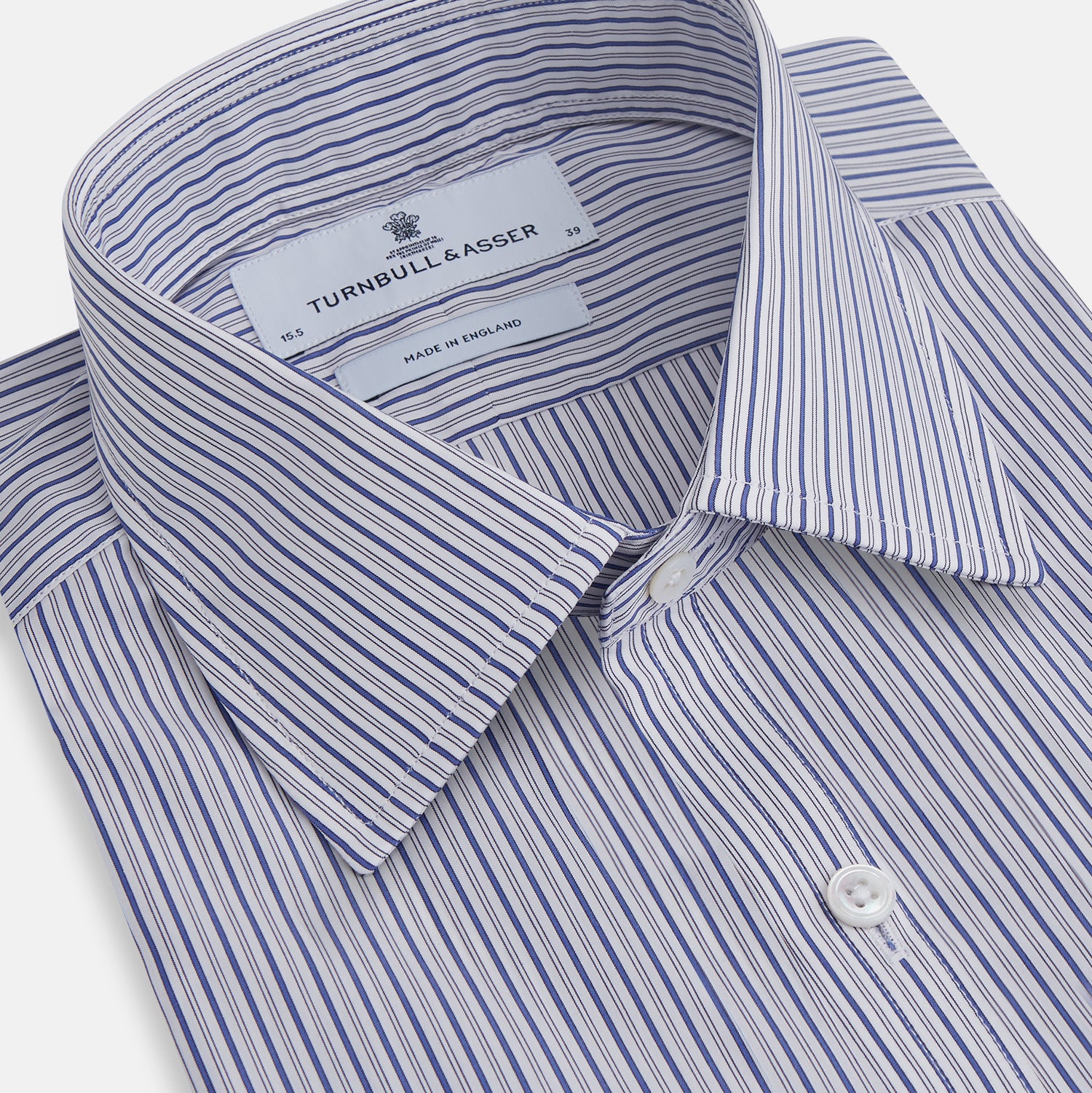 Image 2 of product The Dark Blue Track Stripe Mayfair Shirt by Turnbull & Asser is a long-sleeve, button-up Egyptian cotton shirt with a classic collar and thin blue and white stripes, laid flat on a white background.