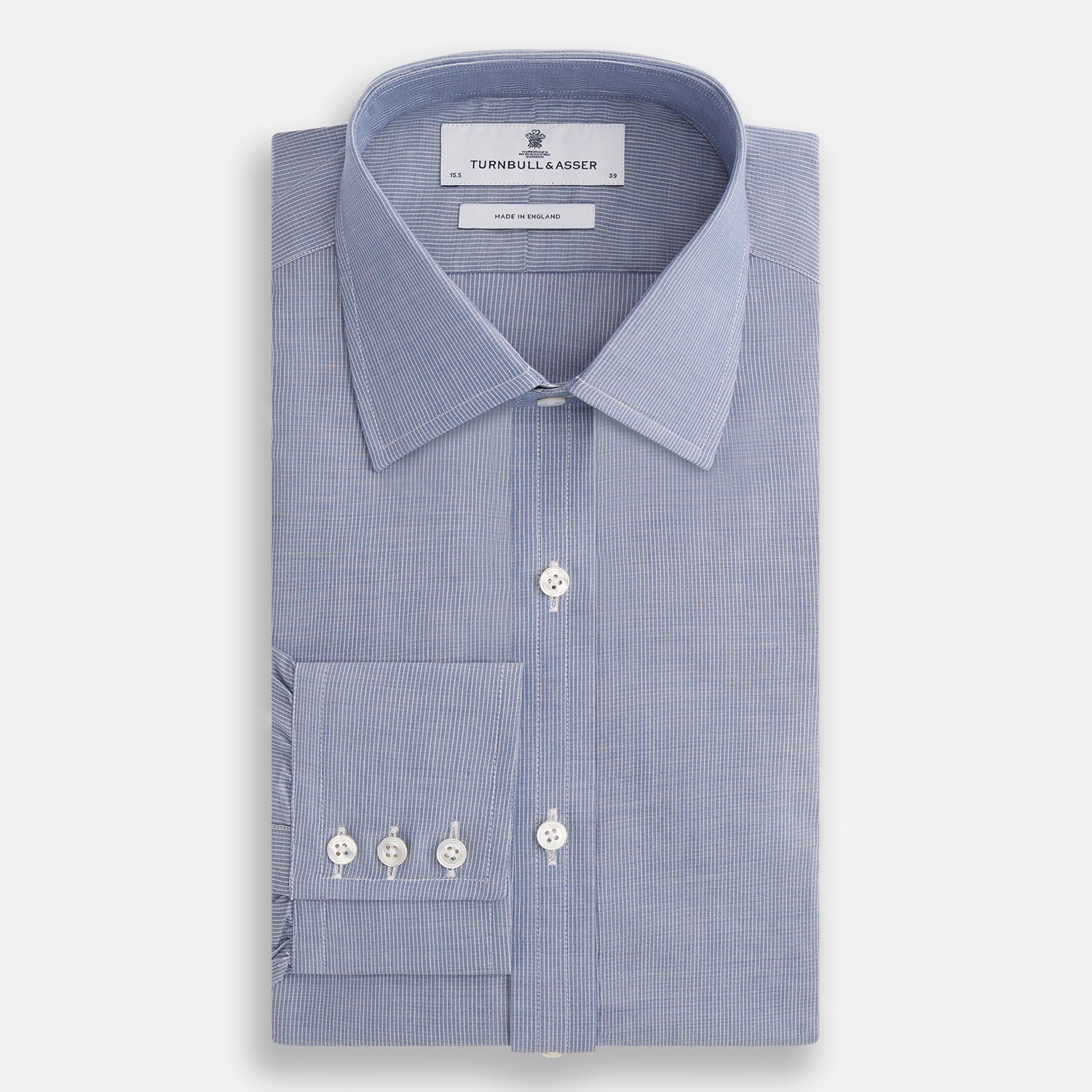 Image 4 of product The Turnbull & Asser Blue Pencil Stripe Mayfair Shirt is crafted from organic cotton with a classic collar, white buttons, and buttoned cuffs. Shown laid flat on a white background.