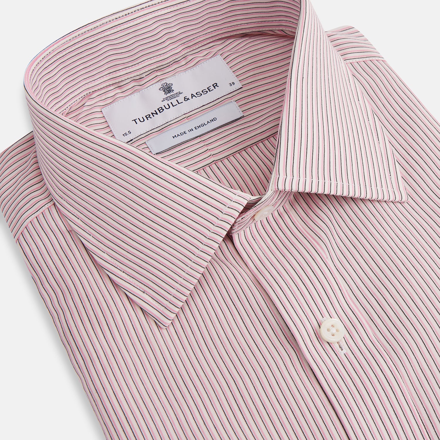 Image 2 of product The Turnbull & Asser Pink Fine Shadow Stripe Mayfair Shirt is a long-sleeved button-up with a classic T&A collar, crafted from pure cotton and featuring thin pink and white vertical stripes, shown on a plain white background.