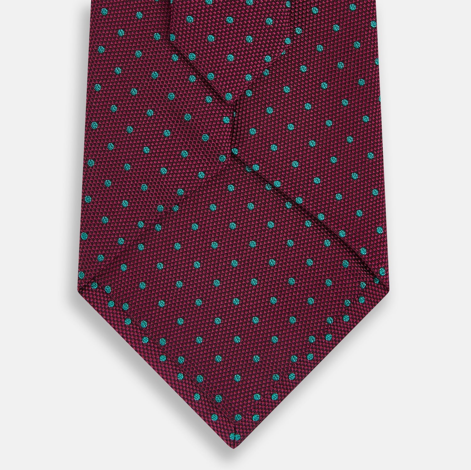 Image 3 of product A rolled-up Turnbull & Asser Green and Magenta Micro Dot Silk Tie, featuring small, evenly spaced magenta dots on green silk, displayed on a plain white background—an ideal accessory for sophisticated outfits.