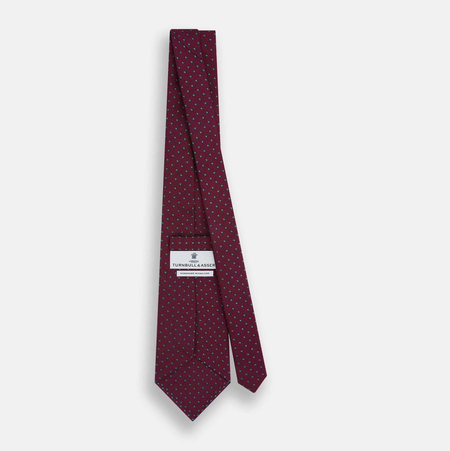 Image 4 of product A rolled-up Turnbull & Asser Green and Magenta Micro Dot Silk Tie, featuring small, evenly spaced magenta dots on green silk, displayed on a plain white background—an ideal accessory for sophisticated outfits.