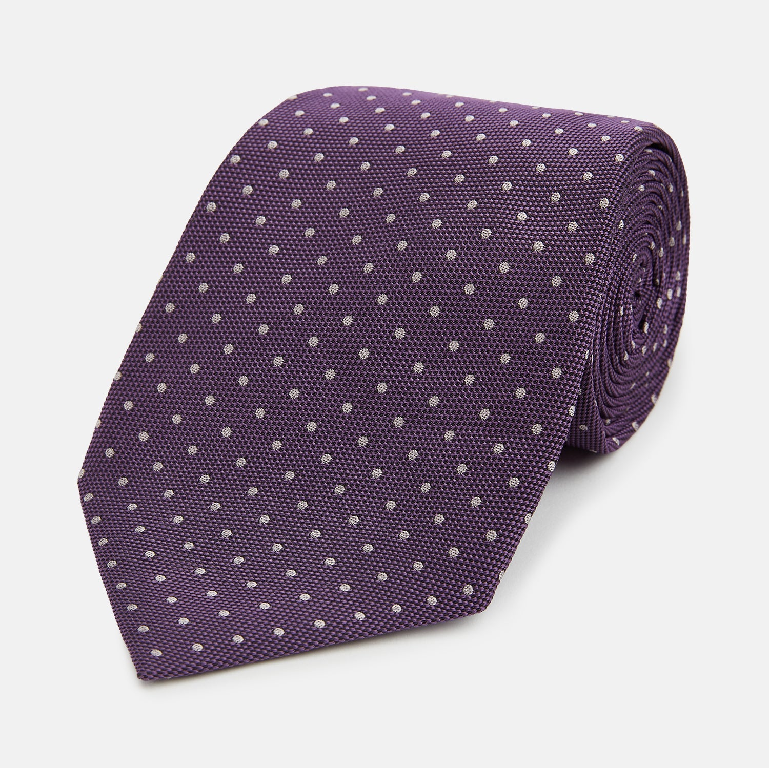 Image 1 of product The Turnbull & Asser Lilac and Purple Micro Dot Silk Tie, featuring a subtle white micro-dot pattern, is rolled up and displayed on a white background—an essential addition to any polished wardrobe.