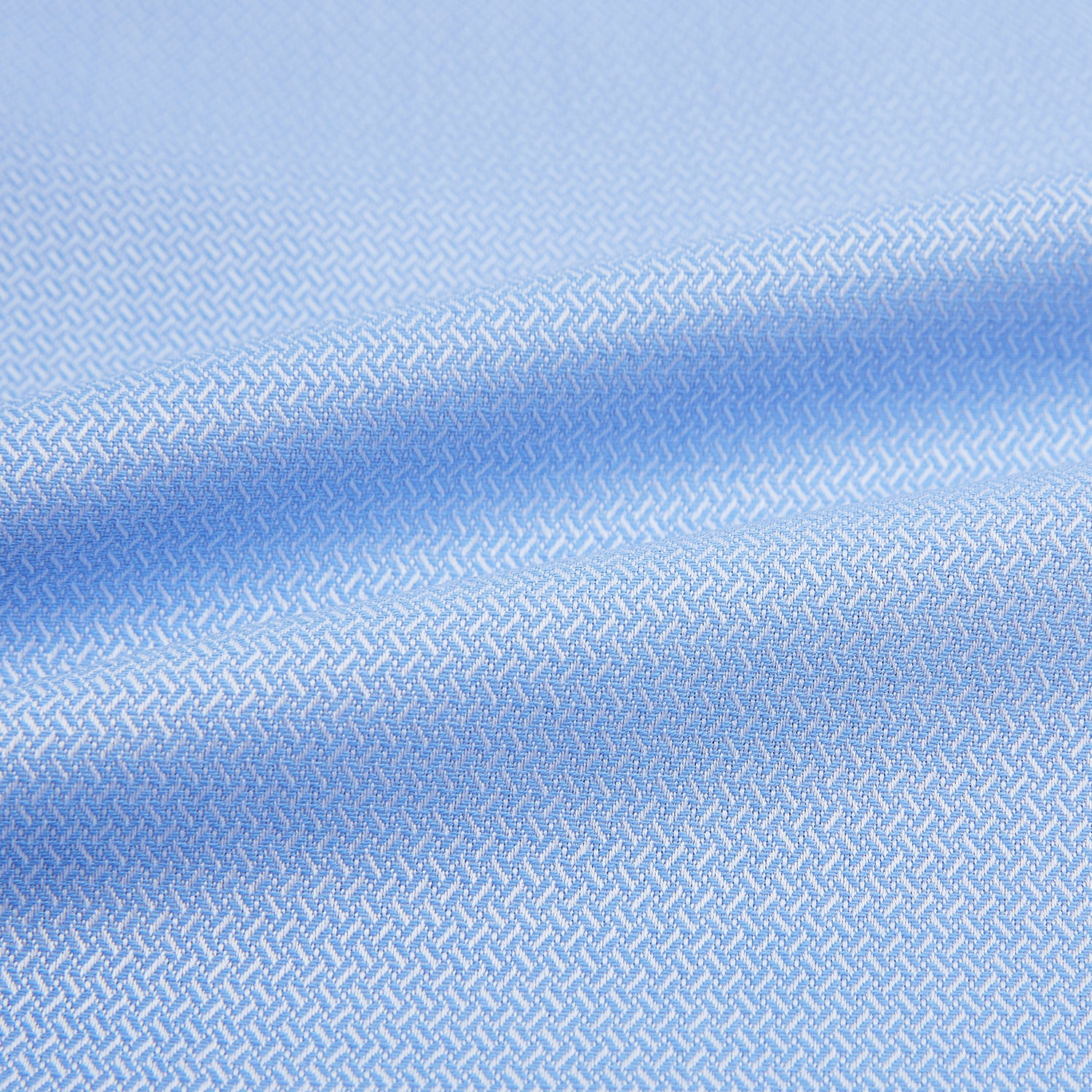 Image 6 of product The Blue Herringbone Mayfair Shirt by Turnbull & Asser features light blue and white stripes, long sleeves, a classic collar, white buttons, and buttoned cuffs. Shown on a plain white background, it's perfect for formal occasions.