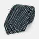 The Turnbull & Asser Navy Geometric Floral Silk Tie features a dark blue background with a repeating small geometric pattern in light blue, yellow, and red, shown rolled up on a plain white surface.